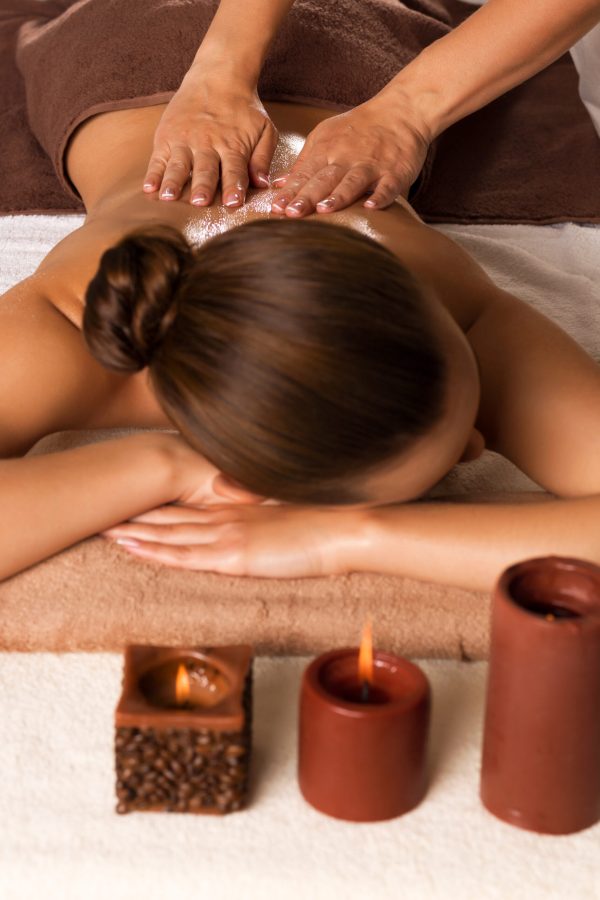 Masseur doing massage on woman body in the spa salon. Beauty treatment concept.