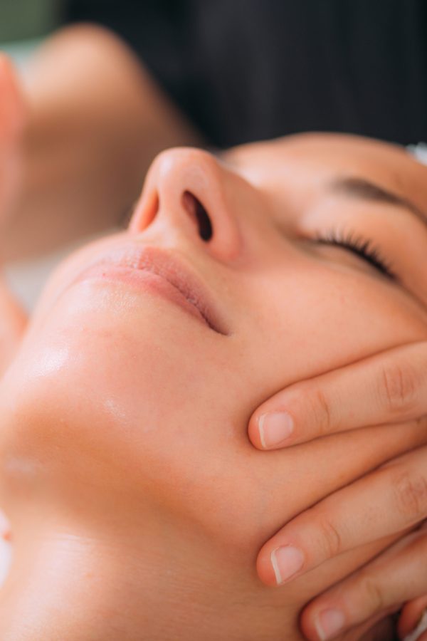 Woman Enjoying a Professional Ayurvedic Facial Massage with Therapeutic Essential Oils